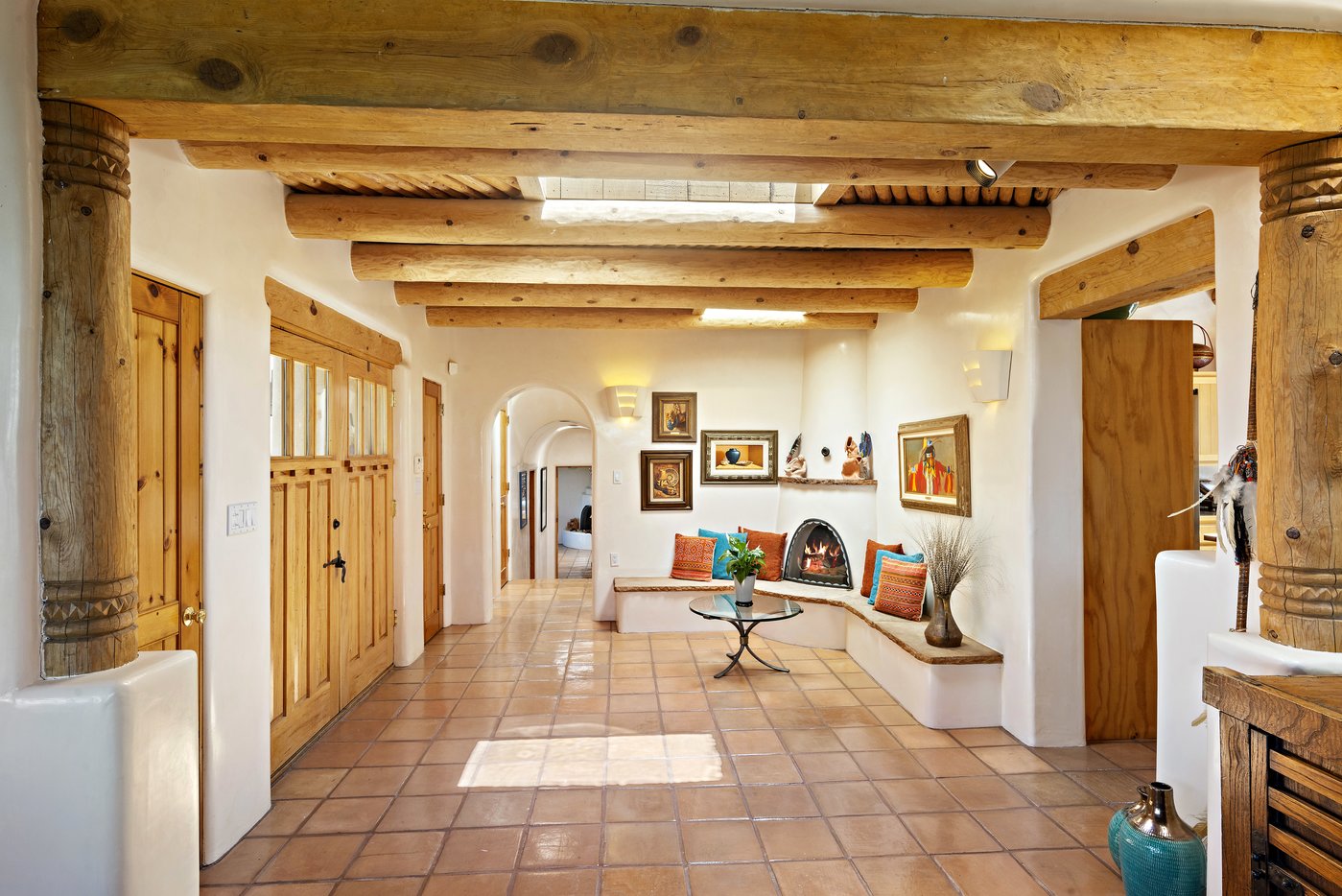 Entryway with banco seating and kiva fireplace as seen from living room